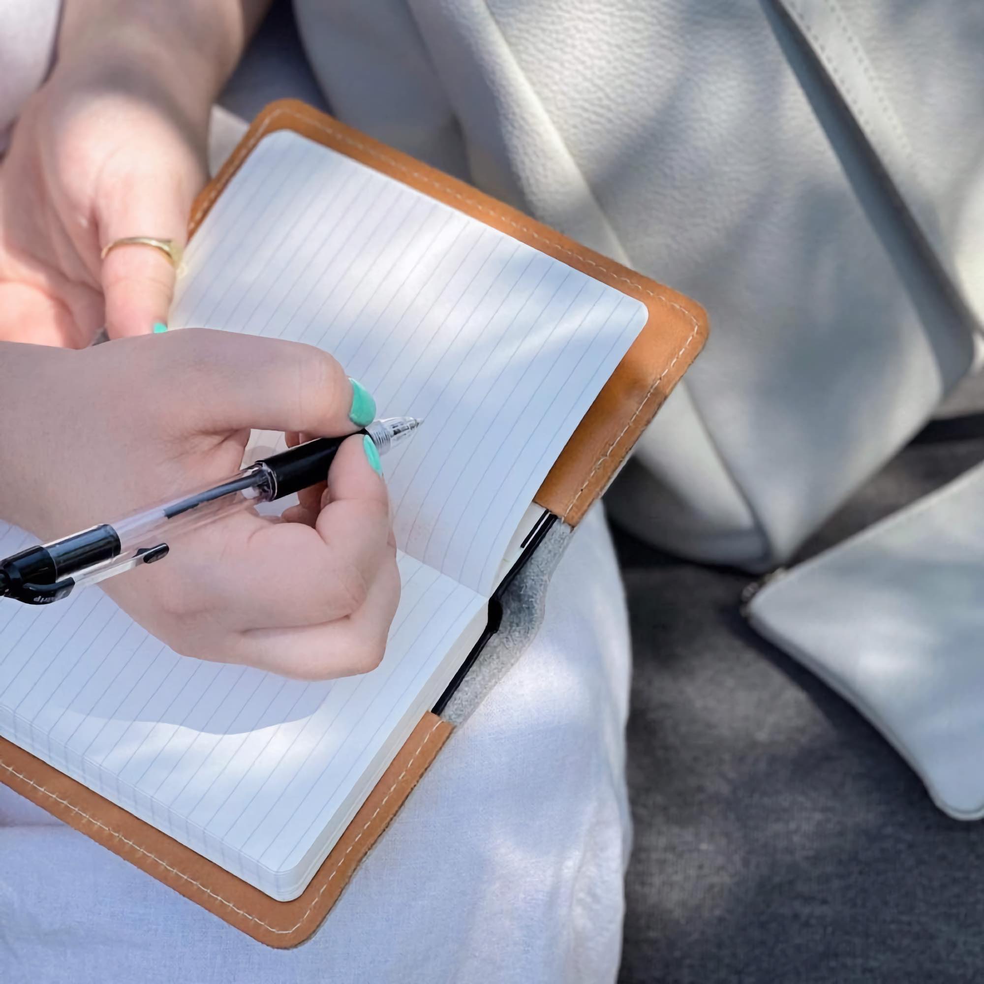 Pocket notebook, pacific leather open with model, pen in hand