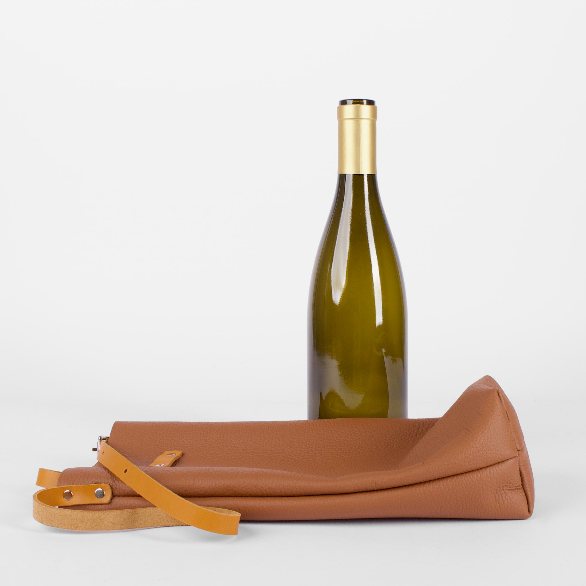 Leather wine bottle carrier bag, Pacific Brandy, flat lay with bottle