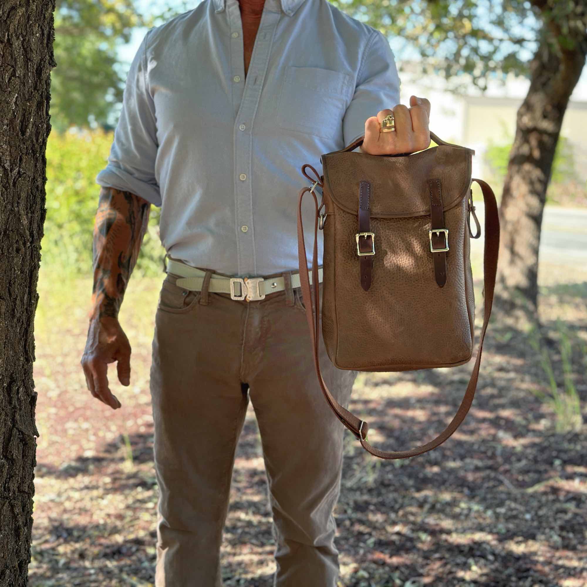 Double bottle wine satchel in cocoa adventure by sonoma county leather hand holding lifestyle